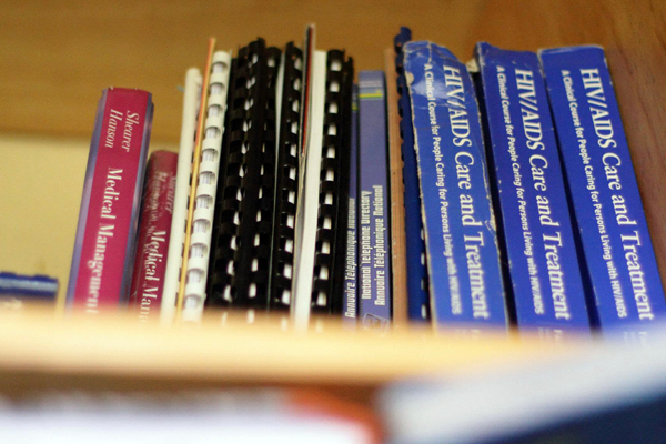 Reference books line a shelf in a rural African clinic.